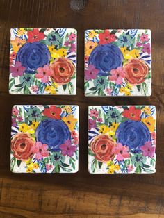 four square coasters with colorful flowers painted on them