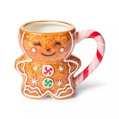 a ceramic gingerbread mug with candy canes on the side and eyes painted to look like a smiling ginger