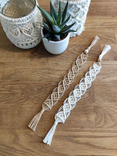 two white crochet tassels next to a potted succulent