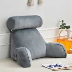 a green reclining chair sitting on top of a white table next to a plant