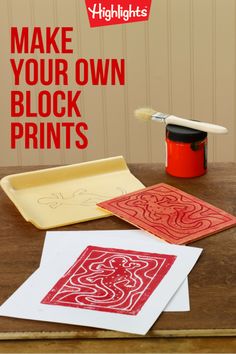 some red and white paper on top of a wooden table next to a paint can