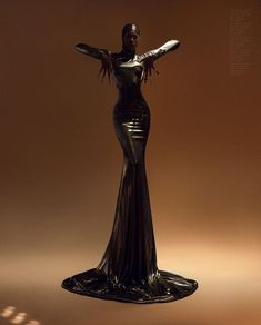 a mannequin dressed in black and silver with her arms spread out to the side