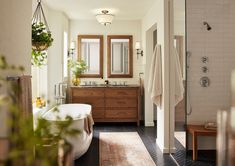 a bath room with a tub a sink and a mirror on the wall in it