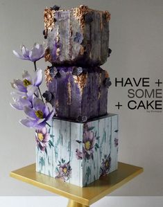 there is a cake with purple flowers on it and the words have some cake written above it