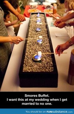 people are standing around a long table with candles on it and the words, 4 have a s'mores bar