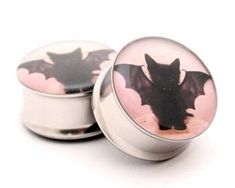 an image of a bat on the front of two plugs for earphones or headsets