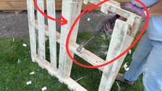 a person using a pair of scissors to cut through the boards on top of a wooden structure