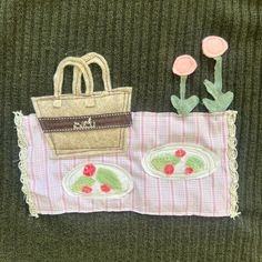 a purse, plate and flower on a table cloth