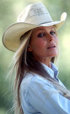 a woman with long hair wearing a cowboy hat