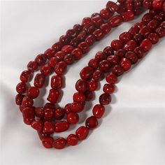 three strands of red glass beads on a white background