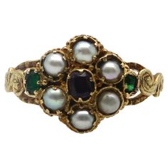 Here at Kirsten’s Corner, we have a sweet spot for these early Victorian flower rings. This 15k gold ring is reminiscent of a Forget-Me-Not flower, a popular motif in the Victorian era. The pearl flower petals in the ring represent tears and capture the romance in our hearts. A central garnet sits delicately amidst a lacy background, while two Old Emerald Cut emeralds add a pop of green to each side of the flower. Each stone is prong set into an early Victorian setting that was traditional for these types of rings. Along the sides is scrolling foliate, hand detailed to look like leaves. A lovely engraving goes all the way around the band of the ring, even detailing the edges of the band. Circa 1850, this is a very old ring that conveys sentimentality and everlasting love. The garnet measur Edwardian Wedding Ring, Victorian Wedding Ring, Emerald Ring Design, Victorian Style Rings, Avon Rings, Medieval Rings, Art Nouveau Ring, Vintage Jewelry Antique, Victorian Engagement Rings