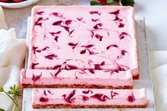 two slices of cheesecake with raspberry topping