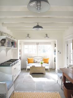 a living room filled with furniture and lots of windows