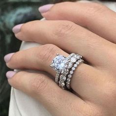 a woman's hand with two rings on her fingers and one ring in the middle