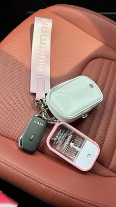 a cell phone and keychain sitting on top of a car seat