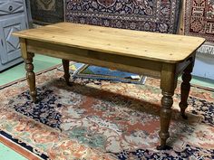 a wooden table sitting on top of a rug in a room filled with rugs