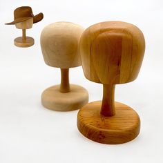 three wooden mannequins with hats on them