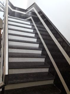 an escalator with black and white stripes going up the stairs in a building