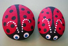 two painted rocks with eyes and a ladybug design on them, sitting side by side