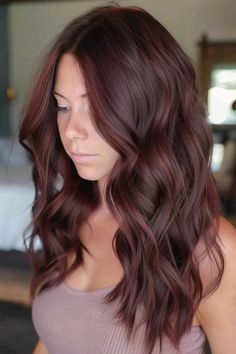 Woman with long, wavy, dark brown hair wearing a sleeveless top. Red Violet Lowlights In Brown Hair, Dark Cherry Hair Balayage, Medium Brown Hair With Burgundy Balayage, Chocolate Burgandy Hair, Chocolate Hair Red Highlights, Burgundy Hair Shadow Root, Red Crimson Hair, Dark Cherry Highlights On Brown Hair, Burgundy And Dark Brown Hair