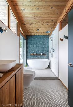 a bathroom with a bathtub, toilet and sink in the middle of the room