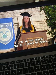 a laptop computer sitting on top of a desk with an image of a woman giving a speech