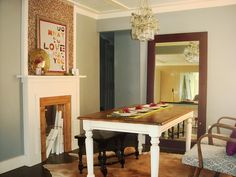 a dining room table with plates on it in front of a fire place and mirror