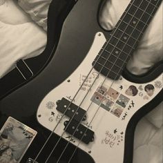 a black and white photo of an electric bass guitar with stickers on it's body