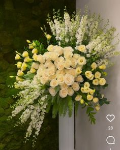 a vase filled with white and yellow flowers