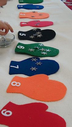 a table topped with lots of different colored snowflakes and mitts on top of it