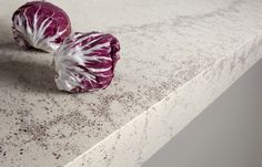 two red cabbages sitting on top of a white counter