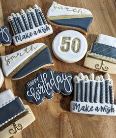 decorated birthday cookies on a wooden table with writing that says happy 50th make a wish