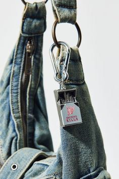 a close up of a person's jeans pocket with a metal keychain