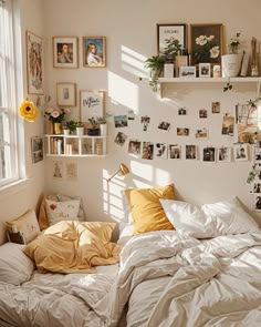 an unmade bed in a bedroom with pictures on the wall and shelves above it