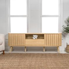 a living room scene with focus on the entertainment center and rug in the foreground