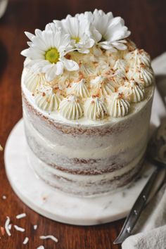 a cake with white frosting and flowers on top