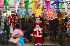 a man dressed as santa claus is walking through a store with lots of christmas decorations