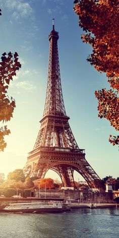 the eiffel tower in paris, france is seen from across the river at sunset