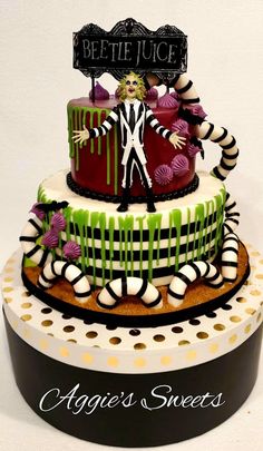 a three tiered cake decorated with green and black icing