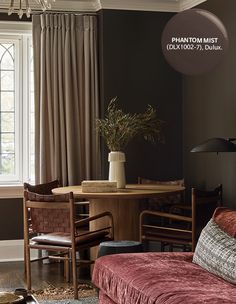 a living room filled with furniture next to a table and a large window covered in curtains