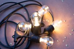 a bunch of light bulbs sitting on top of a table next to a power cord