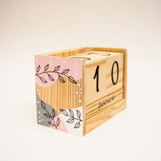 a wooden block with the number ten on it's side and leaves painted on it