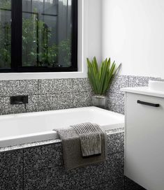 a white bath tub sitting under a window next to a sink