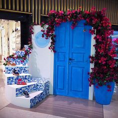 a blue door and steps decorated with flowers