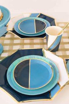 a table set with blue and gold plates