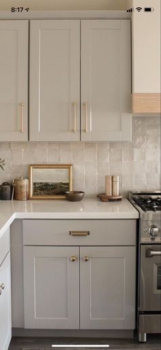 a kitchen with gray cabinets and white counter tops is seen in this image from the front view