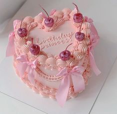 a heart shaped birthday cake with pink decorations