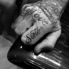 a person's hand with tattoos on it and the word love written in cursive writing