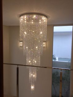 a large chandelier hanging from the ceiling in a room with glass railings