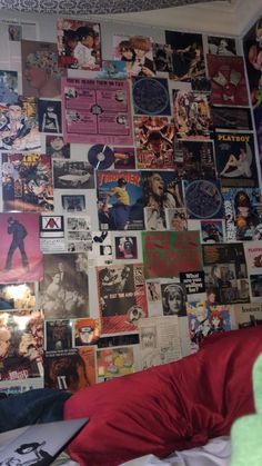 a bedroom with posters all over the wall